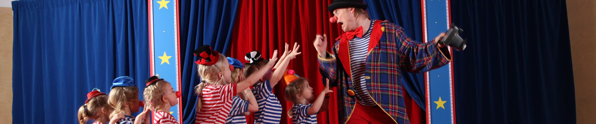 Kindergartenkinder als Clown verkleidet in der Manege